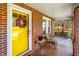 Close-up of the front porch with a wreath on the yellow door and porch swing visible at 712 Springwood Ave, Gibsonville, NC 27249