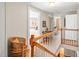 Upstairs hallway with wooden bannister, chair and views of bedrooms and bath at 712 Springwood Ave, Gibsonville, NC 27249