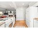 White kitchen features stainless appliances and is open to the living area at 712 Springwood Ave, Gibsonville, NC 27249