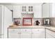 Bright kitchen features white cabinets, granite countertops, and wine glass rack at 712 Springwood Ave, Gibsonville, NC 27249