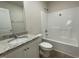 Bathroom featuring a single sink vanity with granite countertop and shower with white tile surround at 72 Heatherglenn Cir, Princeton, NC 27569
