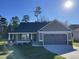 Charming home with a two-car garage, gray siding, covered front porch, and well-manicured lawn at 72 Heatherglenn Cir, Princeton, NC 27569