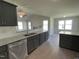 Elegant kitchen featuring granite countertops, stainless steel appliances, and gray cabinets, open to the living area at 72 Heatherglenn Cir, Princeton, NC 27569