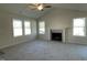 Inviting living room showcasing a cozy fireplace, ample windows, neutral paint, and a ceiling fan at 72 Heatherglenn Cir, Princeton, NC 27569