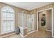 Bathroom featuring a tiled shower with glass door and an arched window at 7604 Derek Dr, Raleigh, NC 27613
