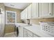 Laundry room features new white front load washer and dryer with plenty of storage at 7604 Derek Dr, Raleigh, NC 27613