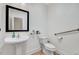 Cozy bathroom with pedestal sink, commode, framed mirror, and neutral color palette at 7687 Mattie Rd, Rocky Mount, NC 27803