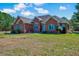 Beautiful brick house with a well-maintained lawn and lush green trees in the background at 7687 Mattie Rd, Rocky Mount, NC 27803