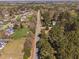 An aerial view of a neighborhood and road flanked by mature trees and well-maintained landscaping at 7917 Blaney Franks Rd, Apex, NC 27539