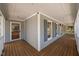 Charming covered porch featuring gray siding, white railings, and dark shuttered windows at 7917 Blaney Franks Rd, Apex, NC 27539