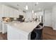 Bright kitchen with large island, stainless appliances, white cabinets, and stylish pendant lighting at 803 Toulouse Ct, Cary, NC 27519