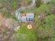 Aerial view features a home nestled among trees with an outdoor firepit at 8504 Old Nc 86, Chapel Hill, NC 27516