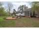Landscaped backyard features a custom fire pit with seating, perfect for outdoor entertaining at 8504 Old Nc 86, Chapel Hill, NC 27516