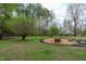 Green backyard features a fire pit, mature trees, and lush landscaping at 8504 Old Nc 86, Chapel Hill, NC 27516