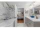 The bathroom has marble walls with a sleek bathtub and double vanity sinks overlooking the bedroom at 8504 Old Nc 86, Chapel Hill, NC 27516