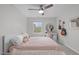 Serene bedroom with a ceiling fan, plush bedding, natural light, and decorative guitars at 8504 Old Nc 86, Chapel Hill, NC 27516
