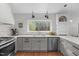 Modern kitchen with gray cabinets, stainless steel appliances, and a picturesque view from the window at 8504 Old Nc 86, Chapel Hill, NC 27516