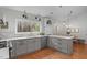 Well-designed kitchen with grey cabinets, modern appliances, and a large window overlooking a wooded area at 8504 Old Nc 86, Chapel Hill, NC 27516