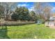 Spacious backyard with lush green grass, mature trees, and a charming playset at 8704 Paddle Wheel Dr, Raleigh, NC 27615