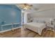 Light-filled bedroom with hardwood floors, ceiling fan, blue accent wall, and white trim at 8704 Paddle Wheel Dr, Raleigh, NC 27615