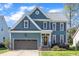 Charming two-story home with blue siding, brown shutters, attached garage, and a well-manicured front yard at 8704 Paddle Wheel Dr, Raleigh, NC 27615