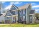 Two-story home with blue siding, brown shutters, attached garage, and a green lawn at 8704 Paddle Wheel Dr, Raleigh, NC 27615
