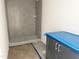 Bathroom featuring new gray-tiled shower and cabinet under blue protective wrap at 908 Colfax St, Durham, NC 27701
