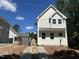 Beautiful new home showing bright white siding, black roof, and concrete driveway at 908 Colfax St, Durham, NC 27701