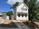 Charming new construction home featuring bright white siding, a metal roof, and a concrete driveway at 908 Colfax St, Durham, NC 27701