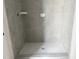 Newly-tiled shower featuring a light gray tile surround and mosaic floor at 908 Colfax St, Durham, NC 27701