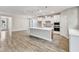 Open-concept kitchen with a large island, stainless steel appliances, and luxury vinyl plank flooring at 9152 Dupree Meadow Dr # 12, Angier, NC 27501