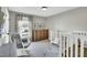 Bright Bedroom with two white cribs, rocker, wood dresser, and neutral decor at 99 Stoney Hill Ln, Sanford, NC 27332