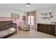 Bedroom featuring pastel-themed decor, a cozy chair, wood crib, and dresser at 99 Stoney Hill Ln, Sanford, NC 27332