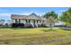 Inviting exterior view showcasing a ranch-style home with a well-manicured lawn and a blooming tree in the yard at 99 Stoney Hill Ln, Sanford, NC 27332