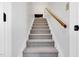 Carpeted staircase with a wooden handrail, leading to the upper level at 99 Stoney Hill Ln, Sanford, NC 27332