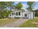 Charming one story home with a well-maintained front yard, white siding and contrasting dark trim at 1001 Helms Pl, Raleigh, NC 27610