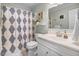 Clean bathroom with white vanity, diamond pattern shower curtain, and neutral-tone decor at 104 Amberhill Ct, Garner, NC 27529