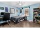 Blue bedroom featuring hardwood floors, a desk, shelving, and good natural light at 104 Amberhill Ct, Garner, NC 27529