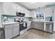 Modern kitchen featuring stainless steel appliances, light blue backsplash, and ample cabinet space at 104 Amberhill Ct, Garner, NC 27529