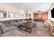 Spacious living room featuring plush gray sectional, hardwood floors, built in cabinets, and large windows at 104 Amberhill Ct, Garner, NC 27529