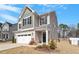 Two-story home featuring a two-car garage and a covered front porch and professional landscaping at 117 Highland Forest Dr, Fuquay Varina, NC 27526
