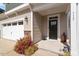 View of the front porch featuring professional landscaping, stone accents and a two-car garage at 117 Highland Forest Dr, Fuquay Varina, NC 27526