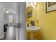 Half bathroom features bright yellow walls, a decorative mirror, and a pedestal sink at 117 Highland Forest Dr, Fuquay Varina, NC 27526