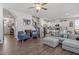 Open-concept living room featuring hardwood floors, a modern ceiling fan and staircase access to upper level at 117 Highland Forest Dr, Fuquay Varina, NC 27526