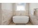 This modern bathtub features beautiful tile, sleek fixtures, and plenty of natural light at 119 November Dr, Durham, NC 27712