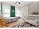 This cozy bedroom features a bed, a crib, and a green accent wall at 119 November Dr, Durham, NC 27712