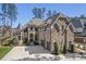 Beautiful stone and brick home featuring manicured landscaping, three car garage, and an elegant turret at 119 November Dr, Durham, NC 27712