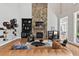 Bright living room featuring a stone fireplace, built-in shelving, and hardwood floors at 119 November Dr, Durham, NC 27712