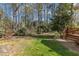 Secluded backyard bordered by mature trees with a wooden deck that blends with the natural surroundings at 131 Long Shadow Ln, Cary, NC 27518
