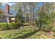 Private backyard featuring a spacious lawn area, surrounded by mature trees, and a natural landscape at 131 Long Shadow Ln, Cary, NC 27518